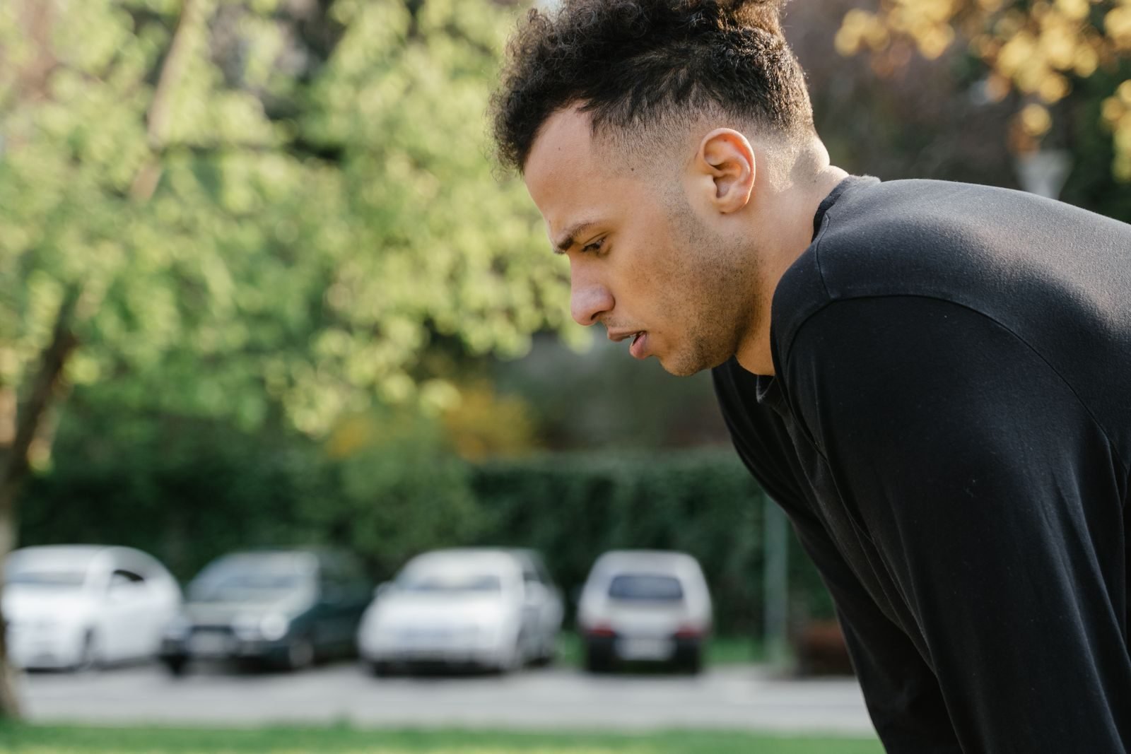 Man in sportswear bending forward to pause because of a side stitch