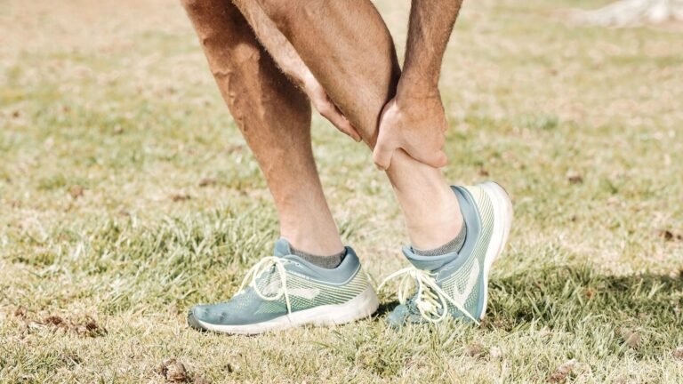 Hombre sujetándose la parte baja de la pierna por dolor de periostitis tibial
