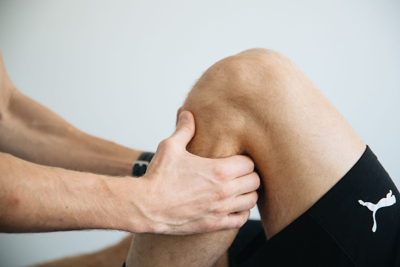 Physiotherapist treating a patient with knee pain from running