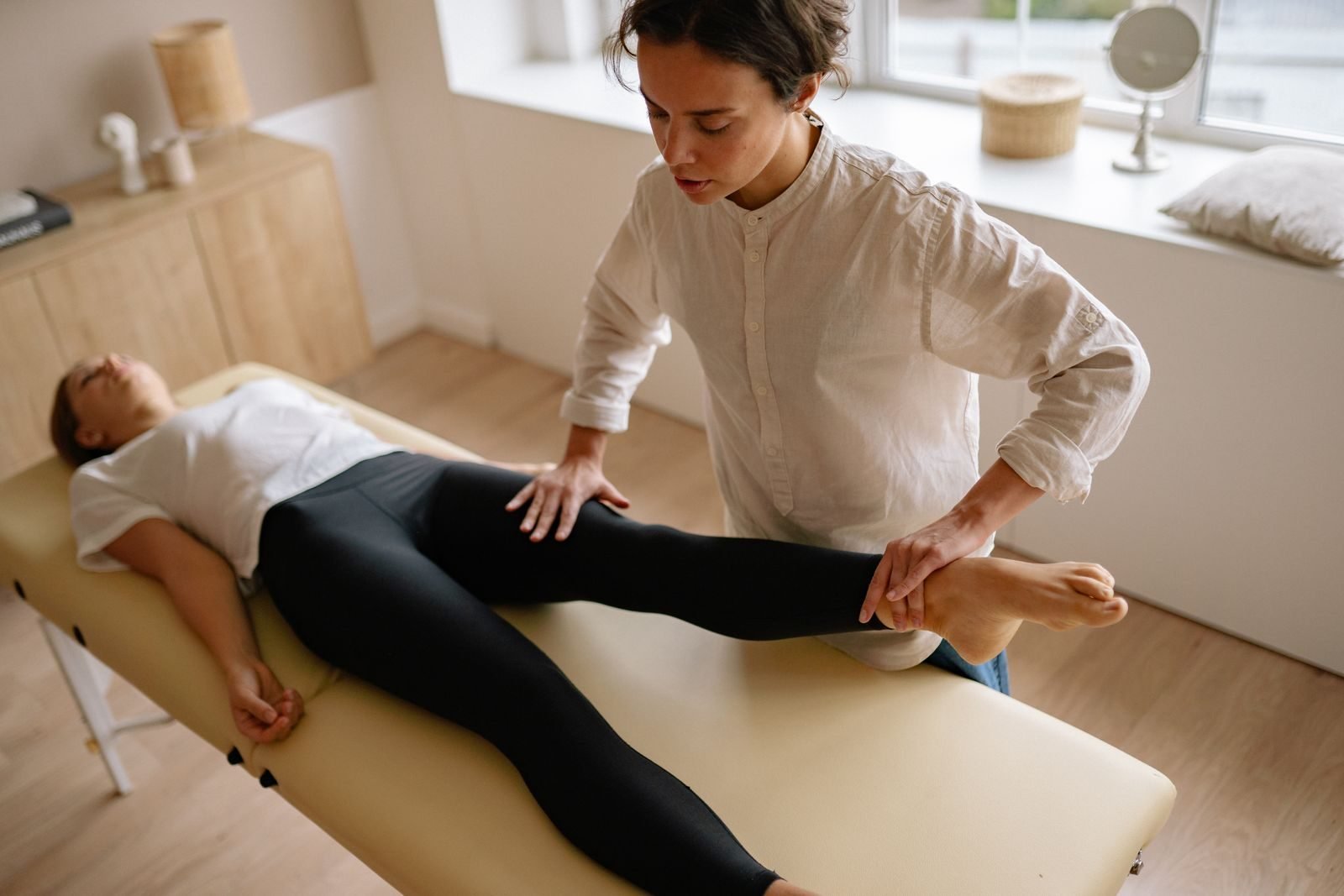 Physiotherapist treating a runner's leg during rehabilitation