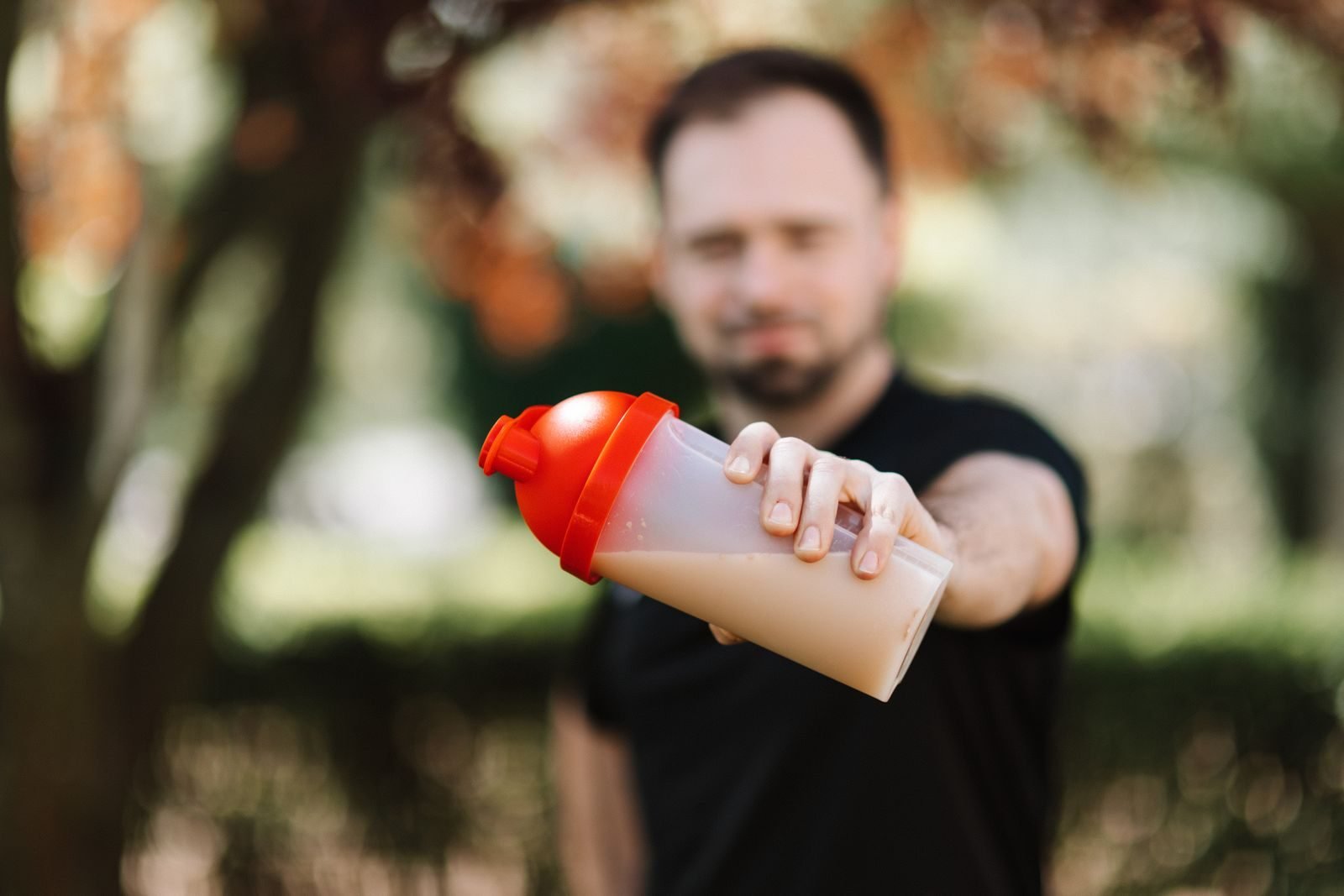 Man showing a shake in a shaker bottle outdoors