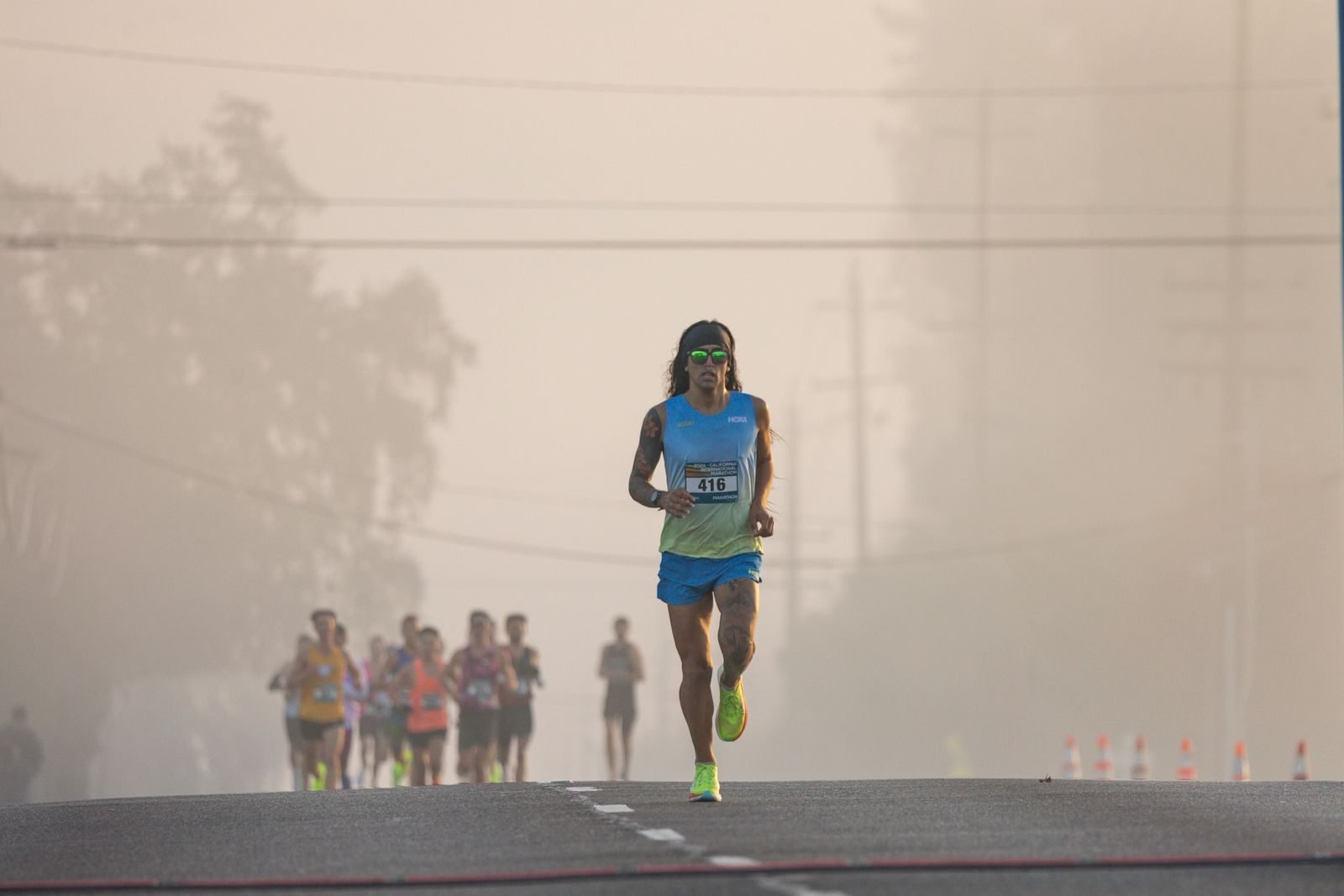 Corredor liderando una carrera por calles con niebla, un esfuerzo que depende del VO2max
