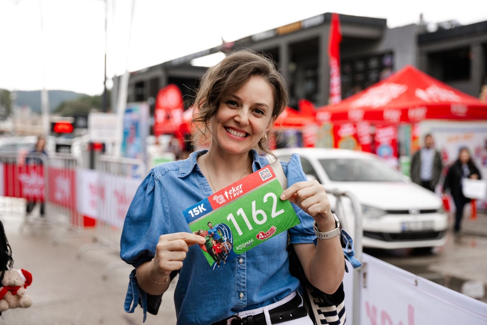 Mujer sonriente mostrando su dorsal antes de una carrera