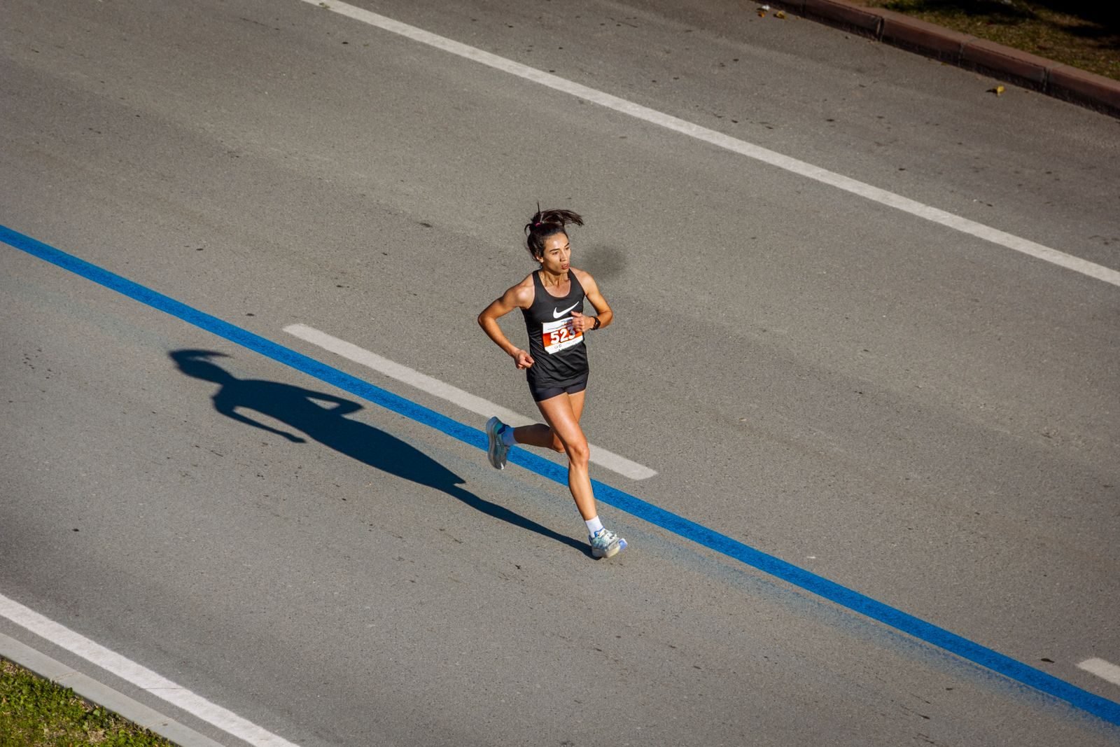 Corredora en solitario por una avenida, como en un intento de récord del mundo de media maratón