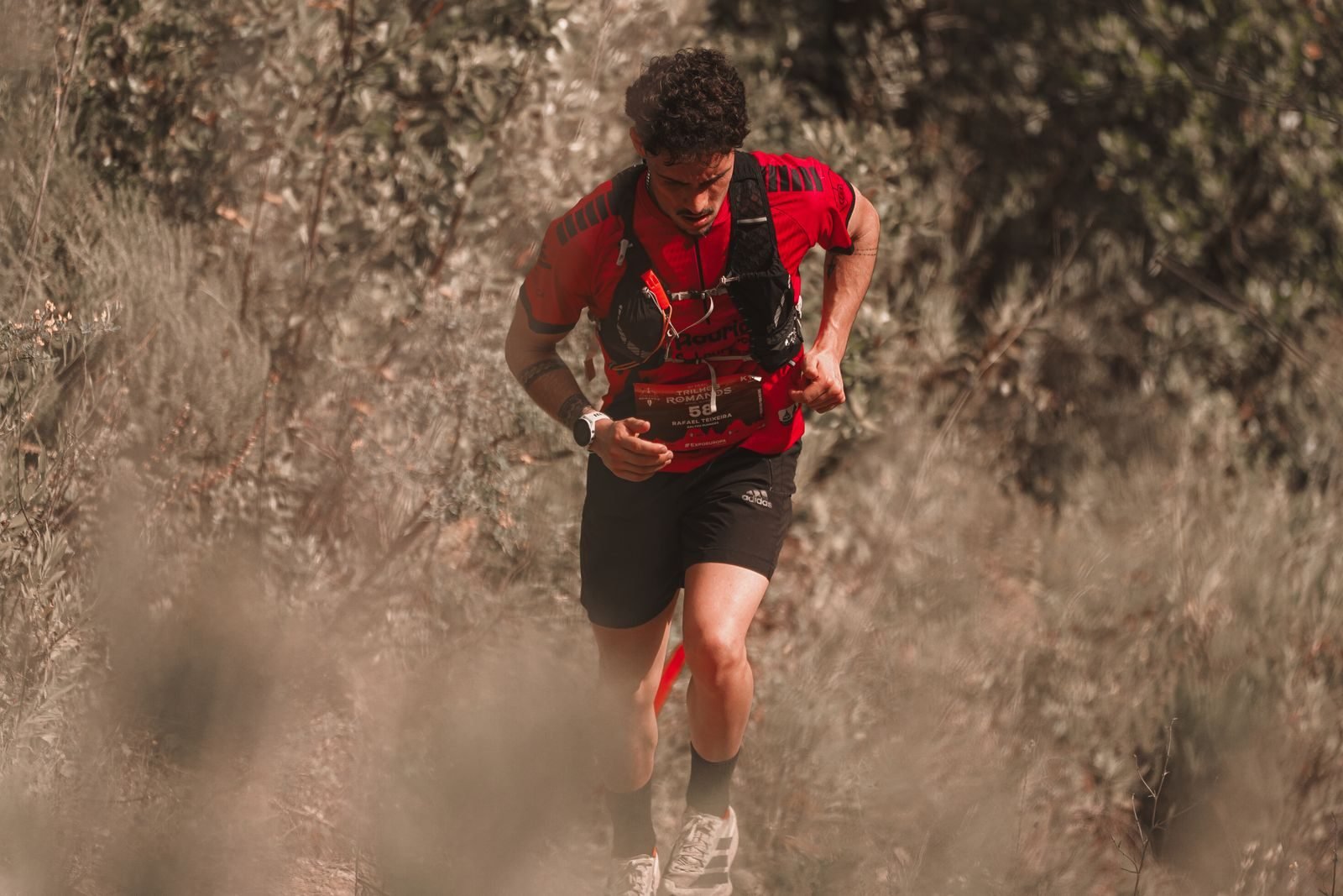 Hombre corriendo por un sendero de montaña en plena naturaleza