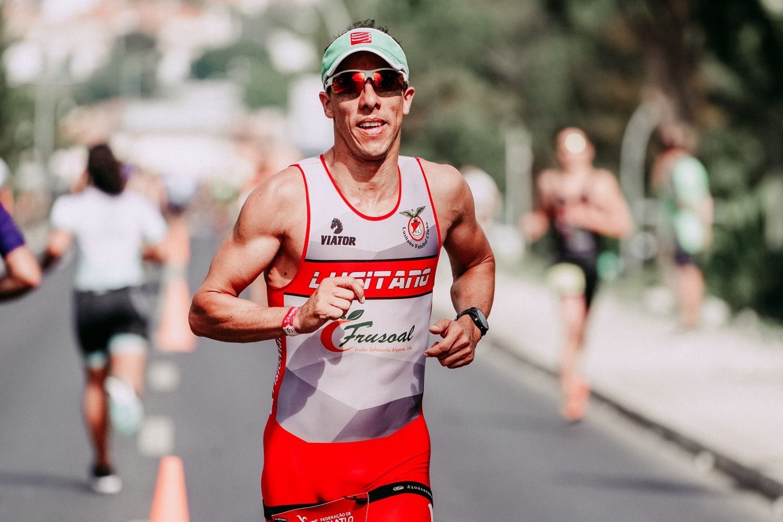 Hombre sonriendo mientras corre un maratón por la carretera