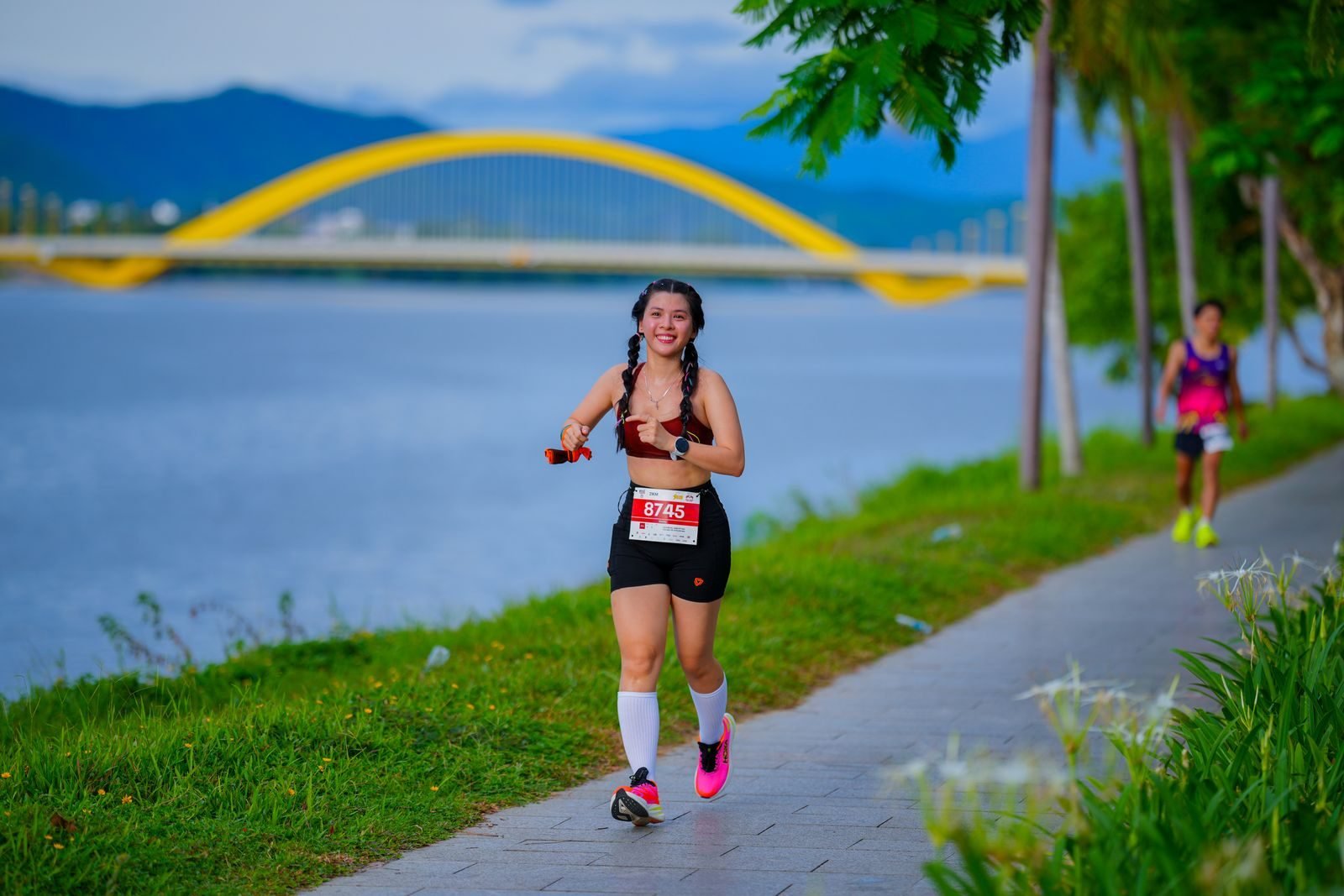 Woman running by the river in a race, the goal of a half marathon training plan