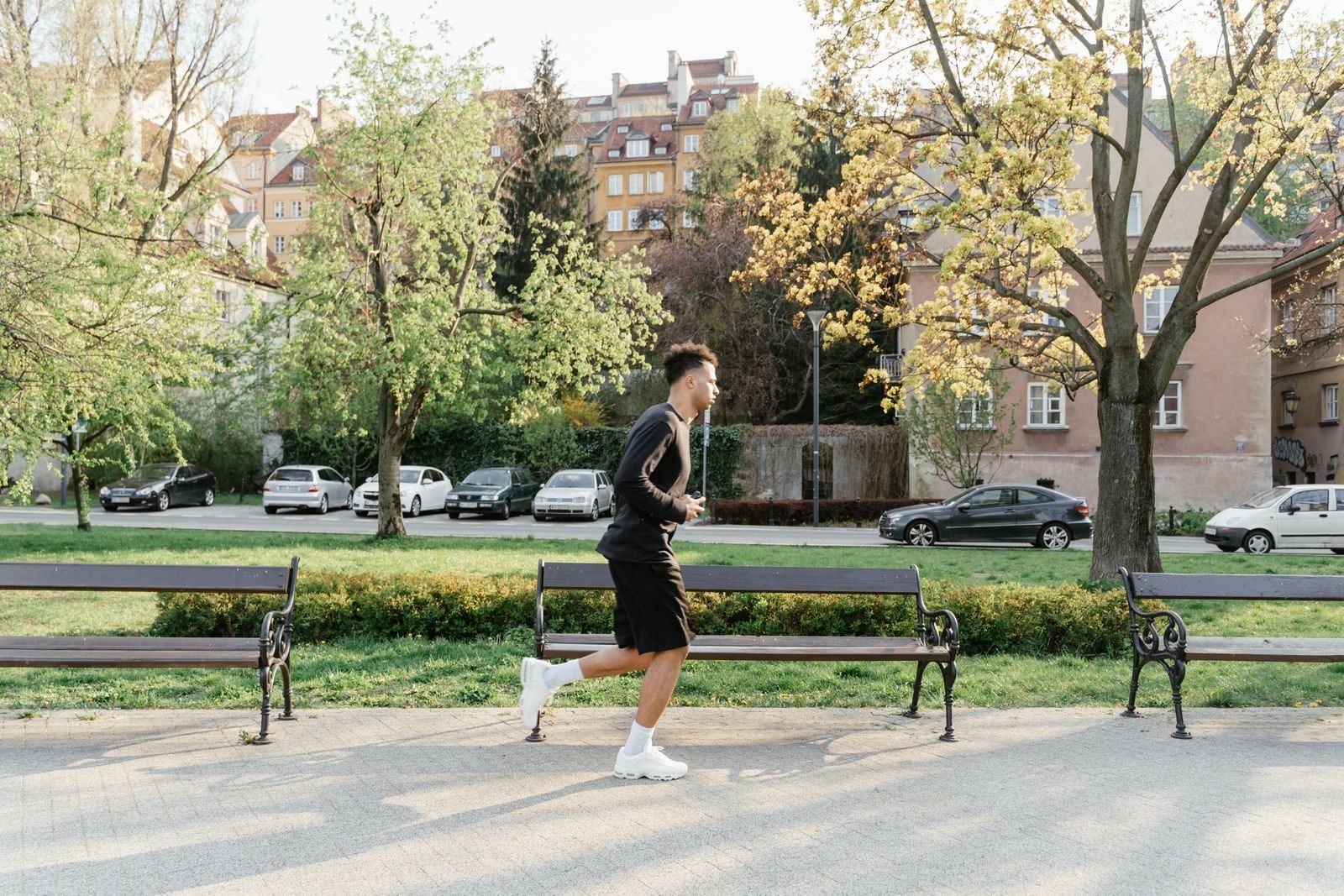 Hombre haciendo un rodaje suave por un parque la semana de la carrera