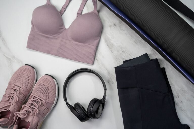 Ropa para correr y accesorios rosas sobre una superficie de mármol