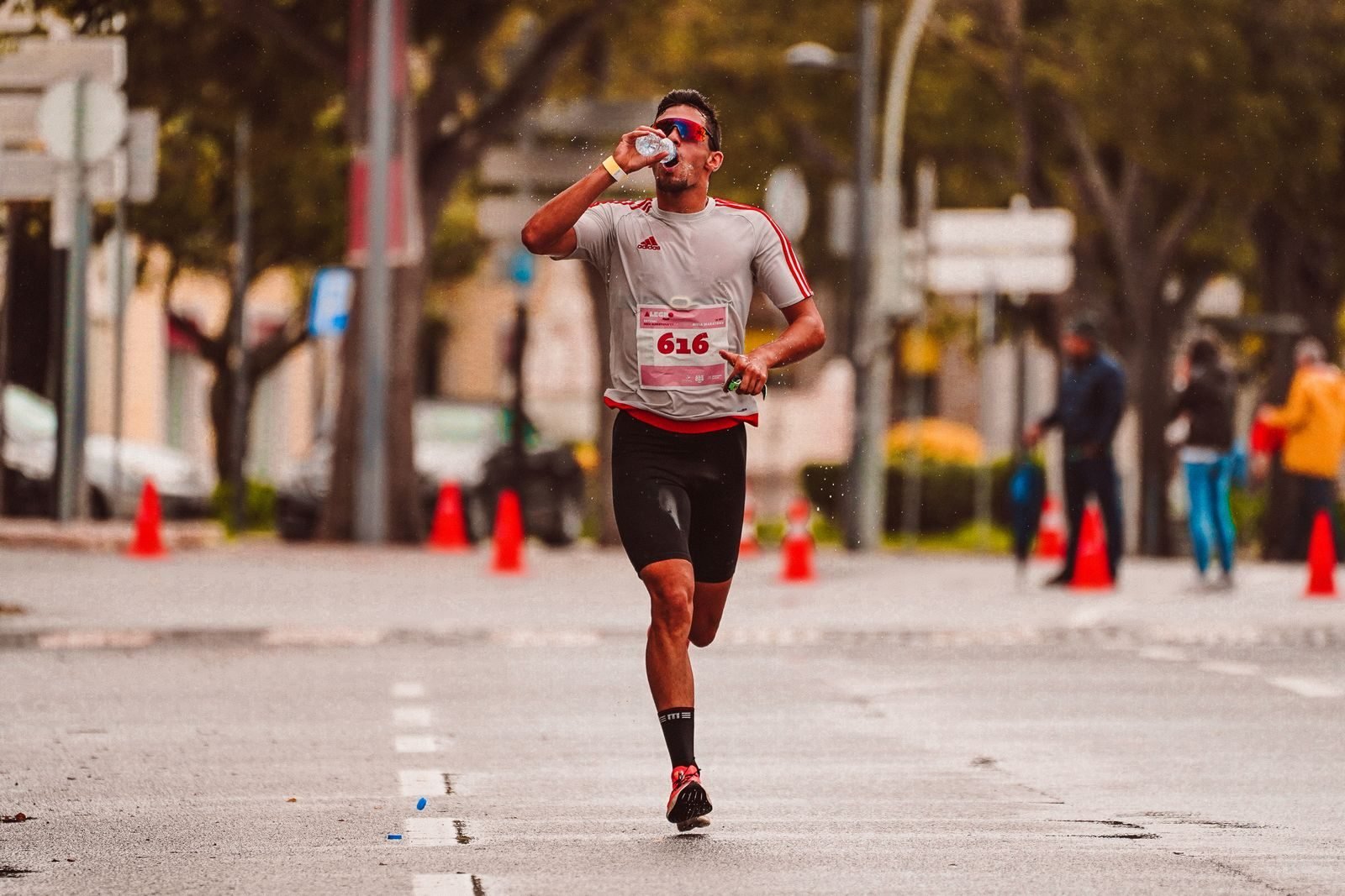 Runner drinking from a bottle during a city marathon