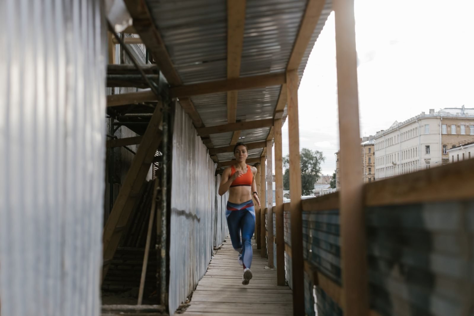 Woman running through a narrow city passage