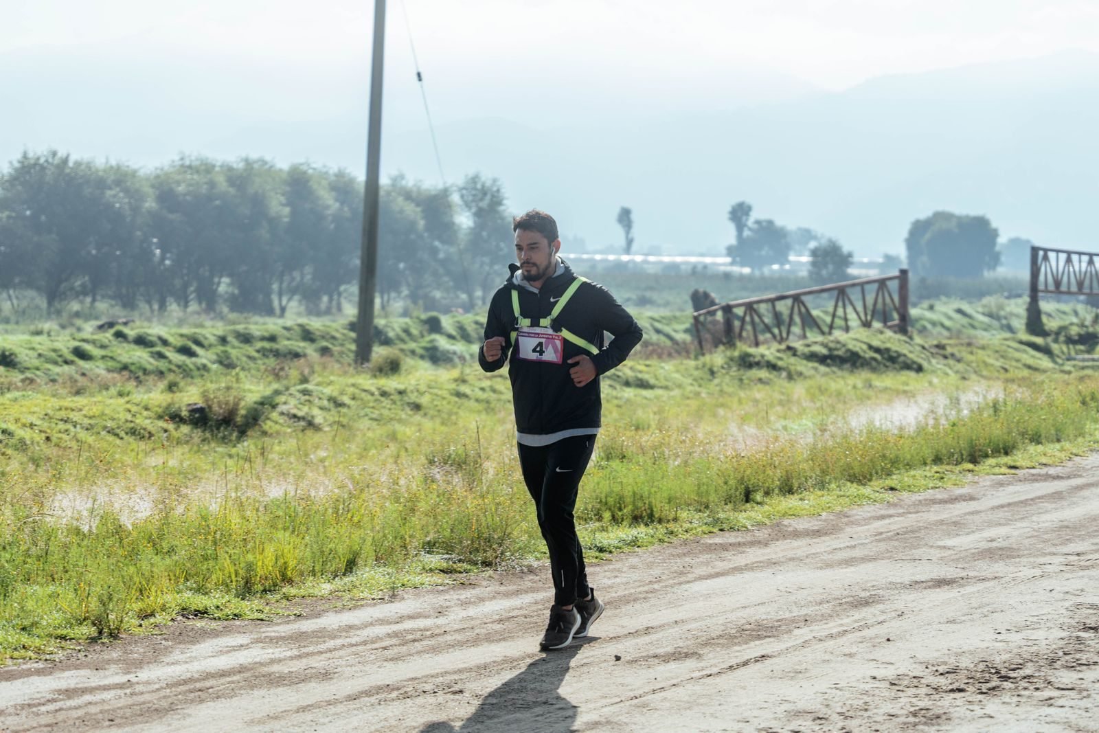Runner in black on a rural dirt path