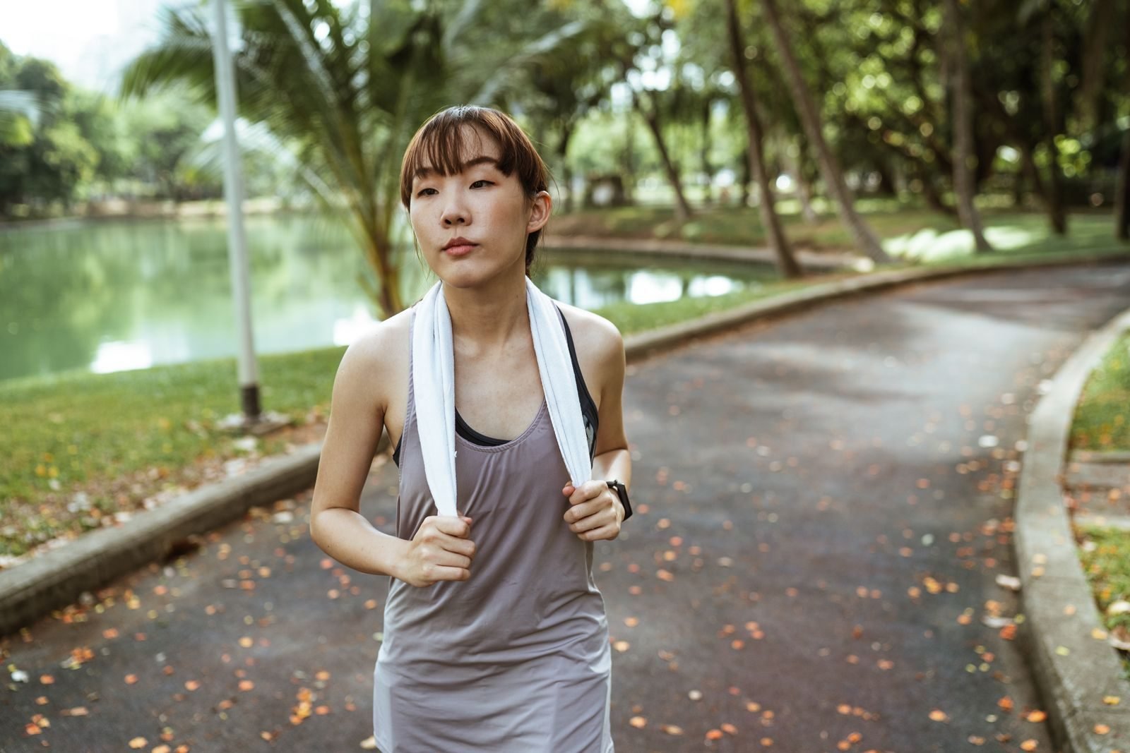 Female runner wearing a sports watch during an easy run in a park