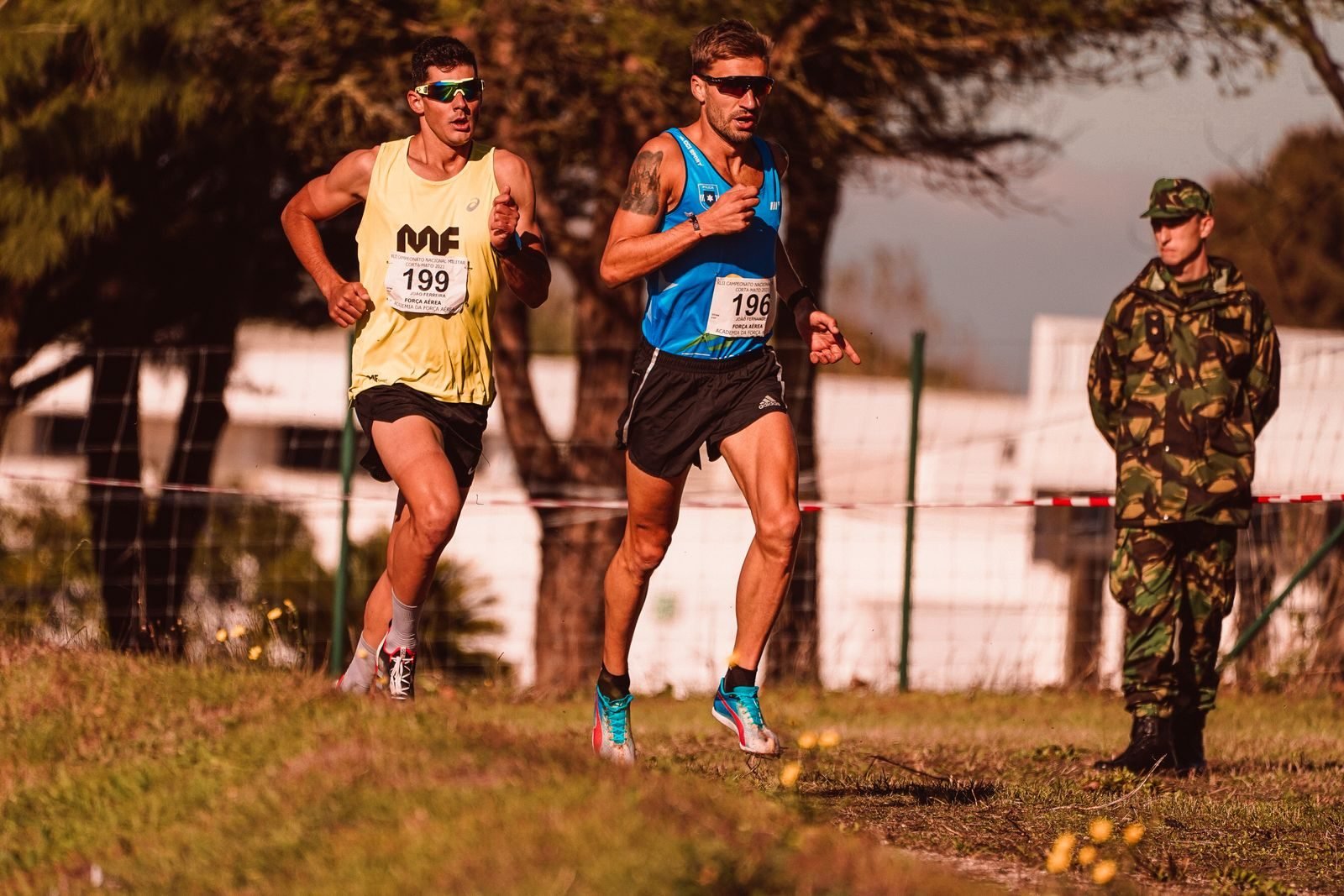 Two runners with race bibs running outdoors