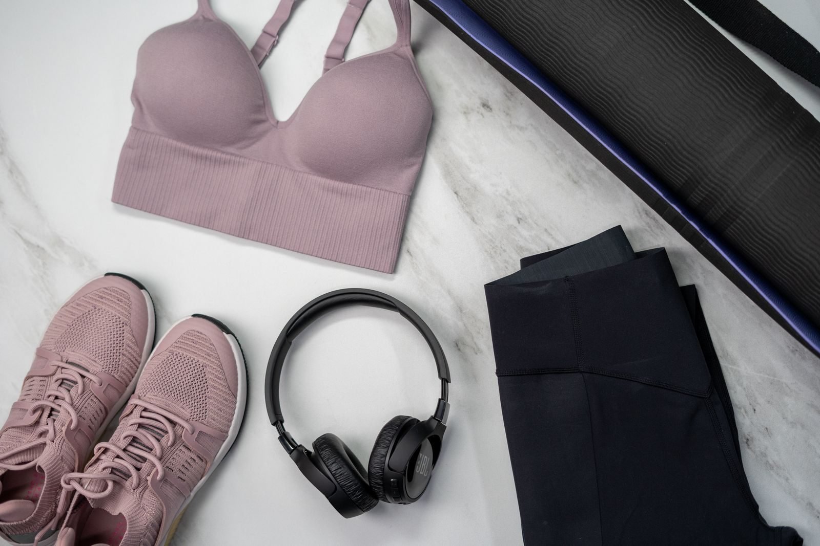 Pink running clothes and accessories on a marble surface