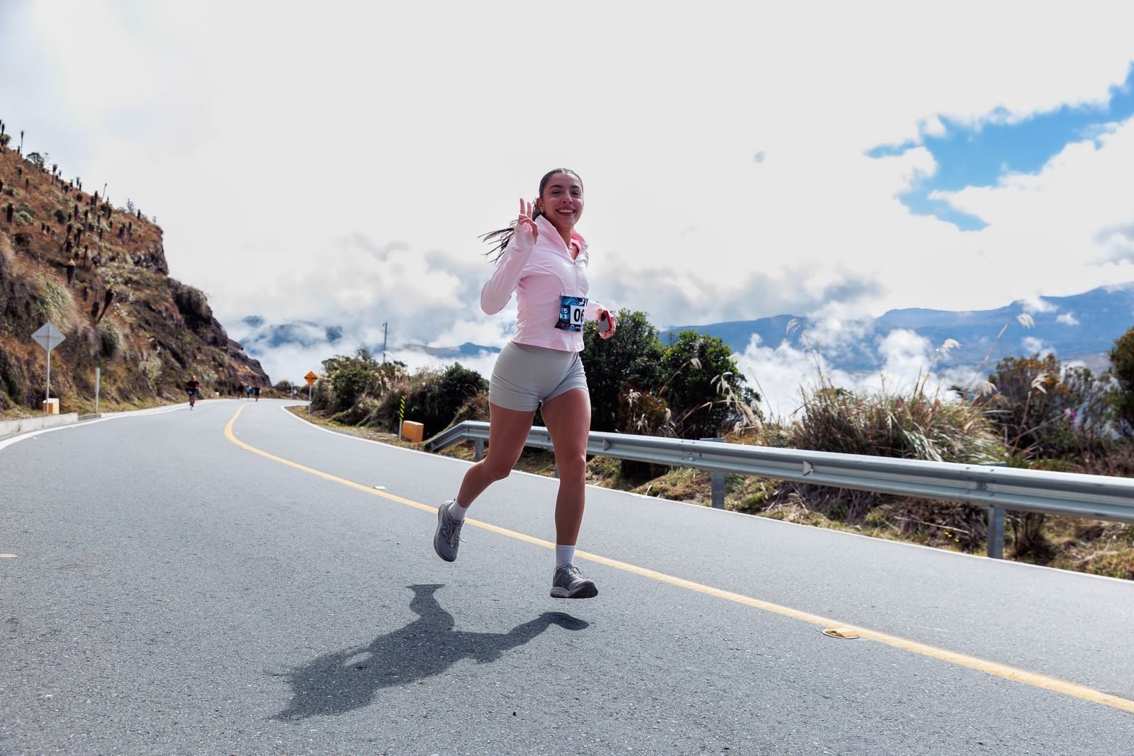 Woman running down a winding mountain road at a good pace