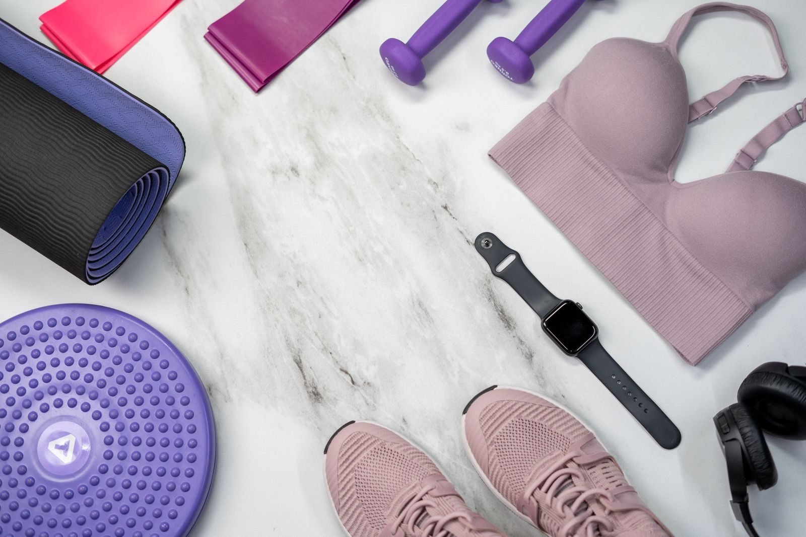 Sports gear with a smartwatch, shoes and clothing on marble