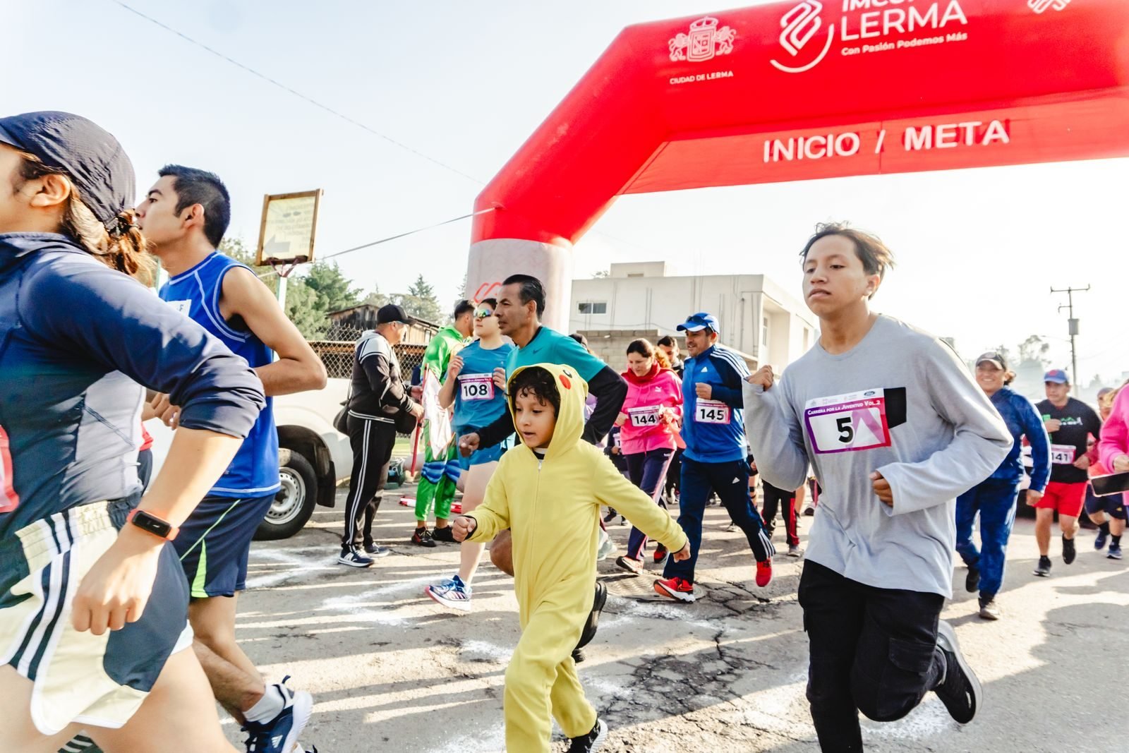 Participantes en la salida de una carrera popular por la ciudad