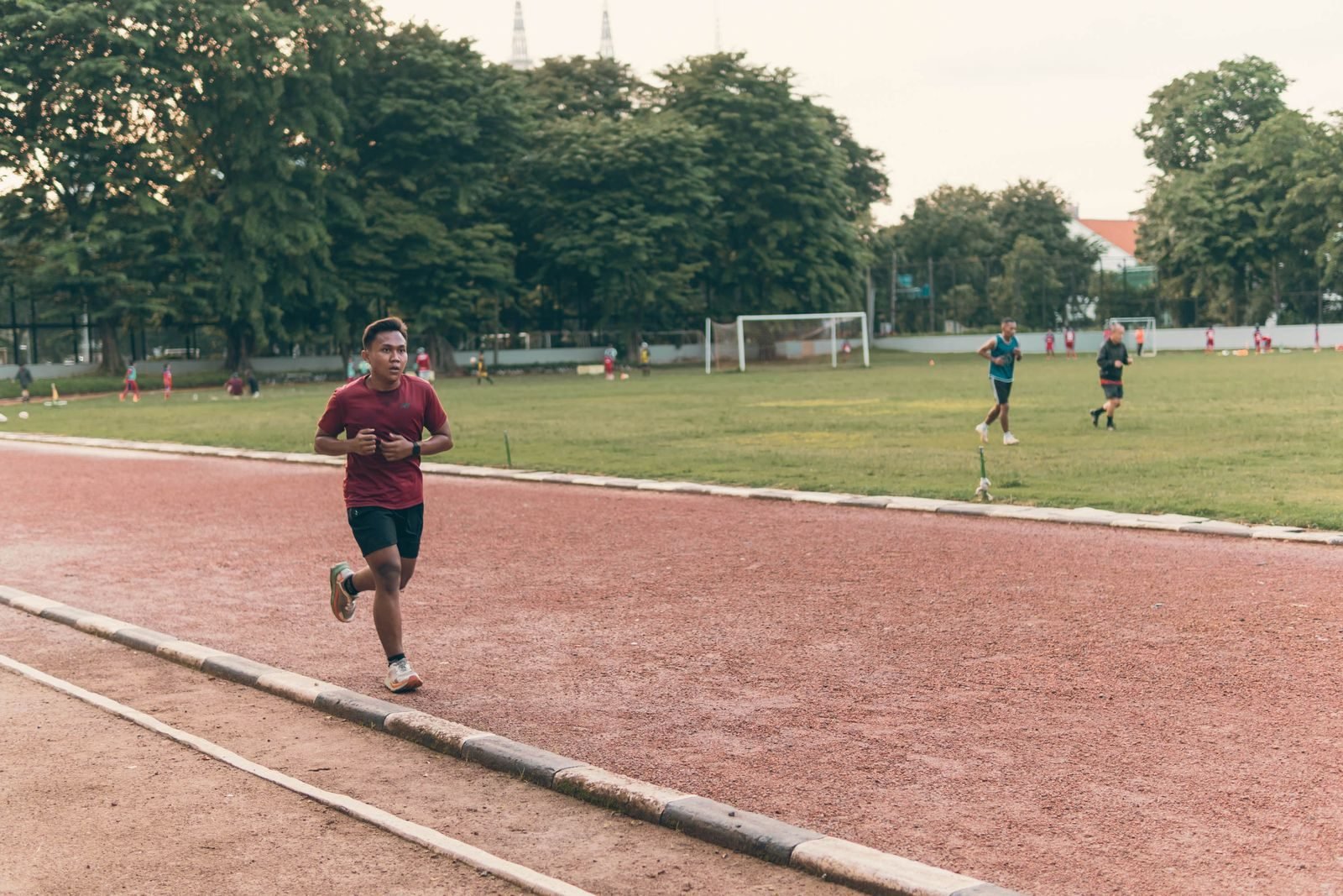 Corredores entrenando series en una pista de atletismo, parte de un plan de entrenamiento 5K
