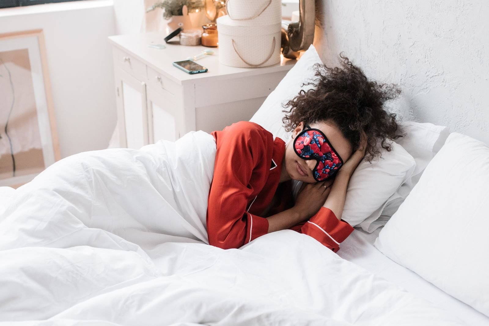 Woman sleeping with an eye mask in a bright bedroom