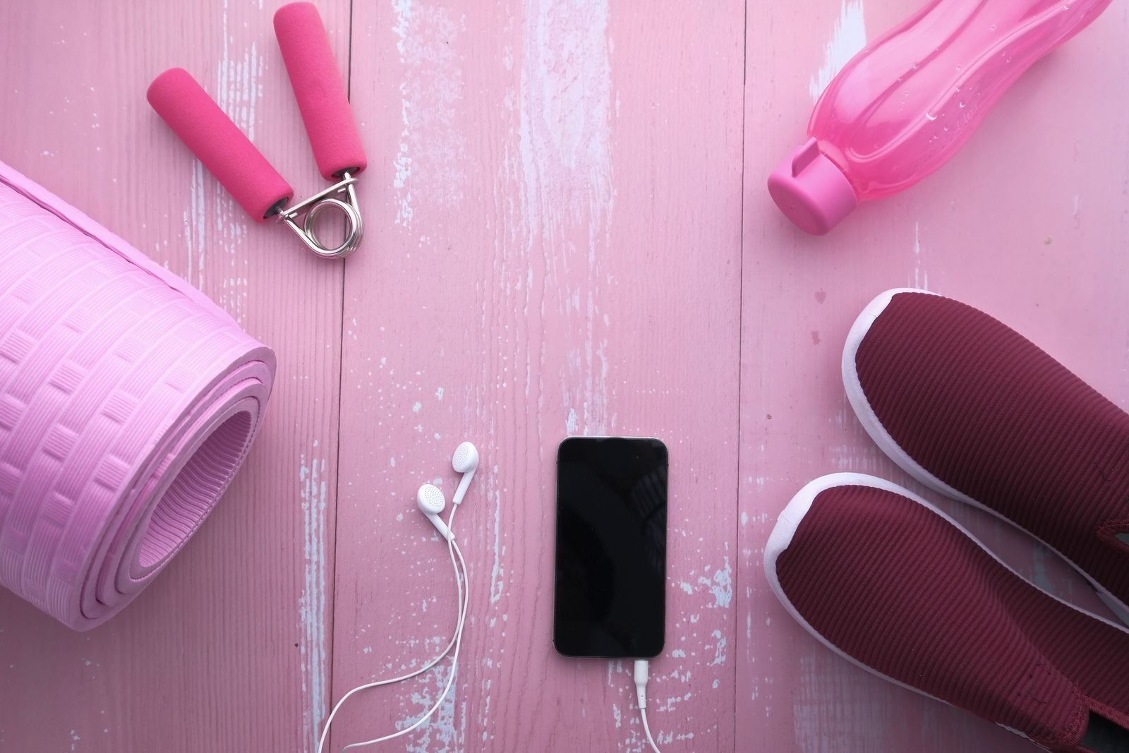 Sports accessories with a mat, shoes, bottle and phone