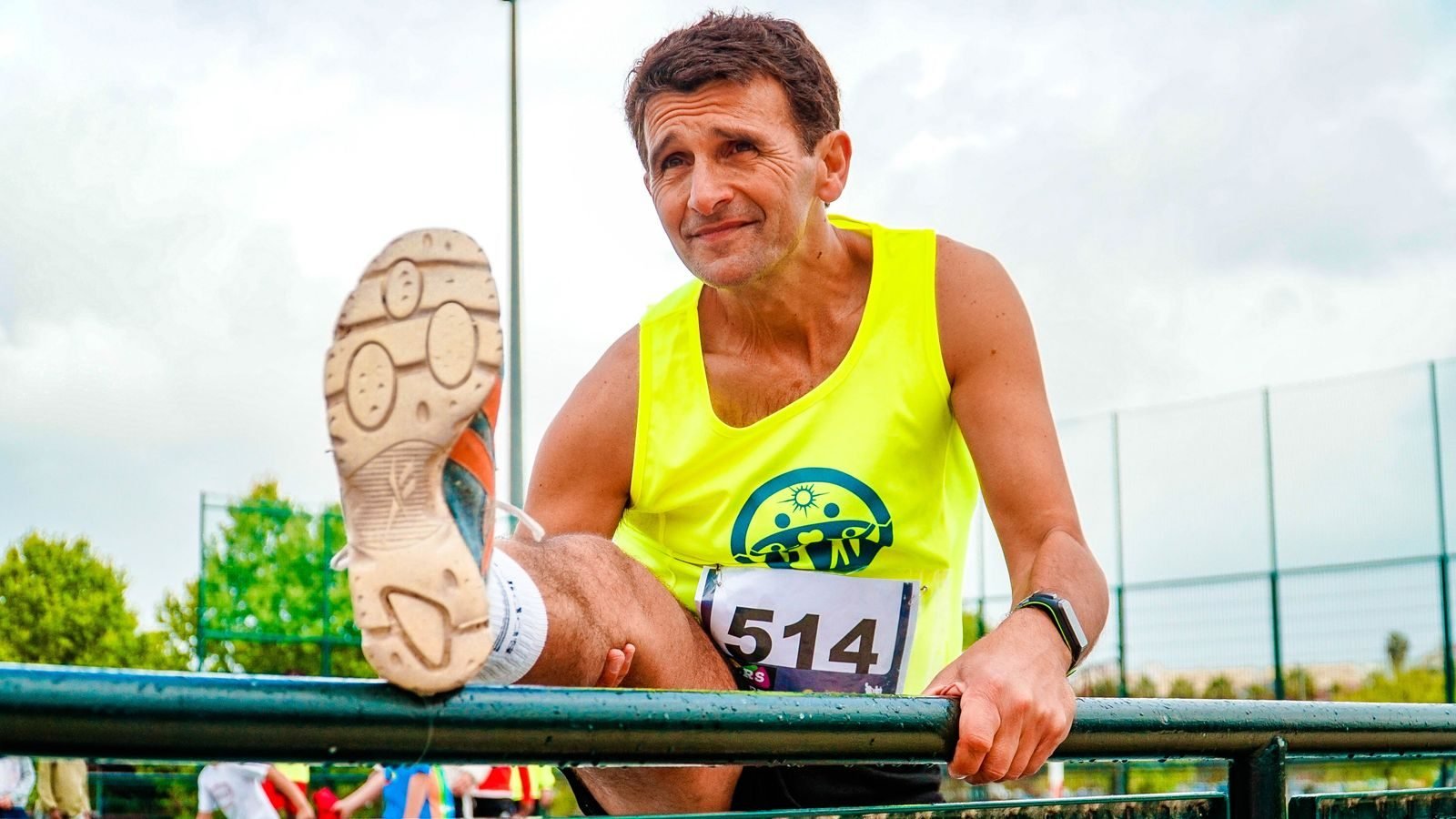Older man stretching by the track before a run