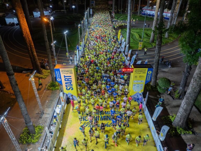 Aerial view of a night marathon start with thousands of runners chasing a sub-4 marathon