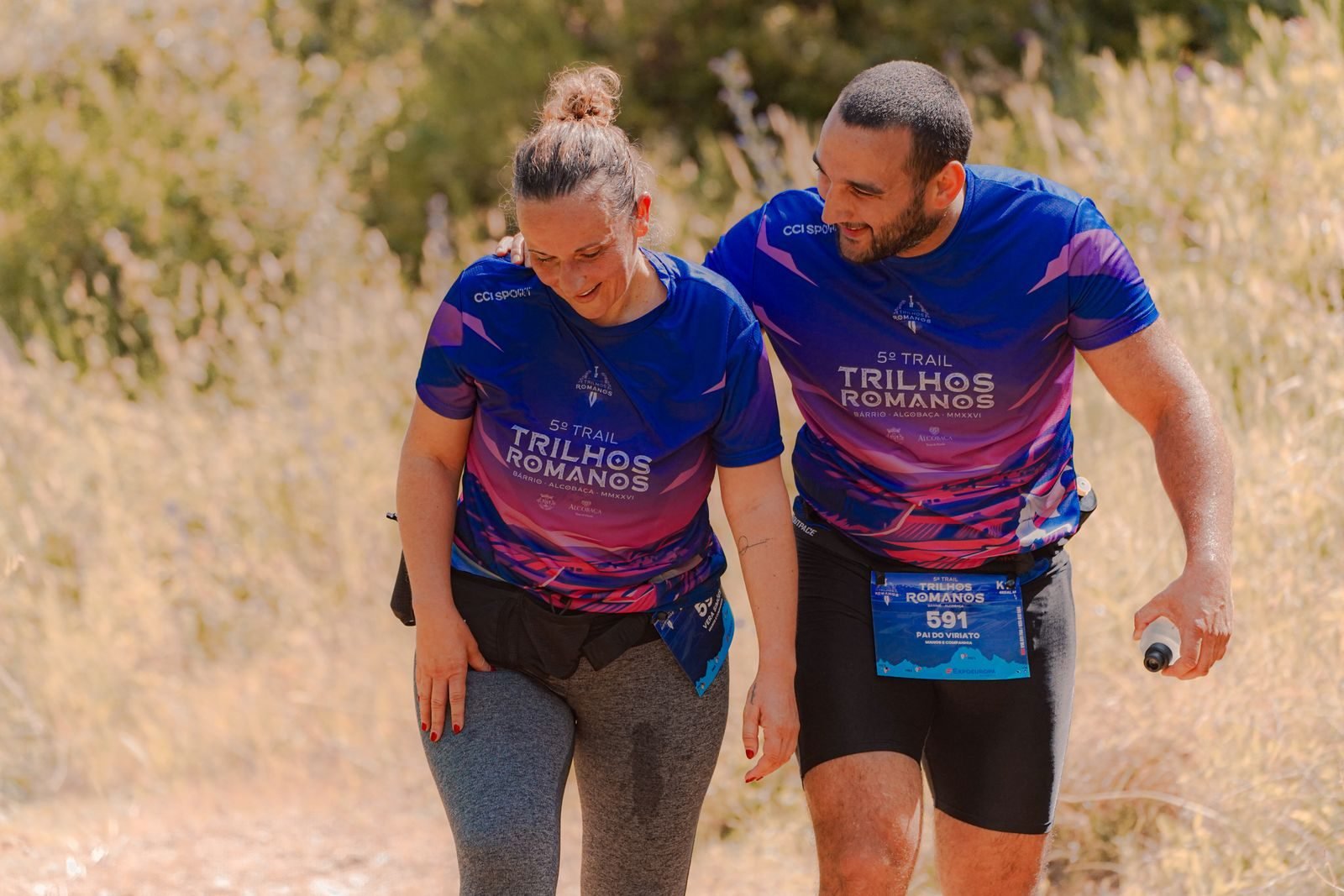 Dos corredores de trail subiendo una cuesta caminando y animándose durante una carrera