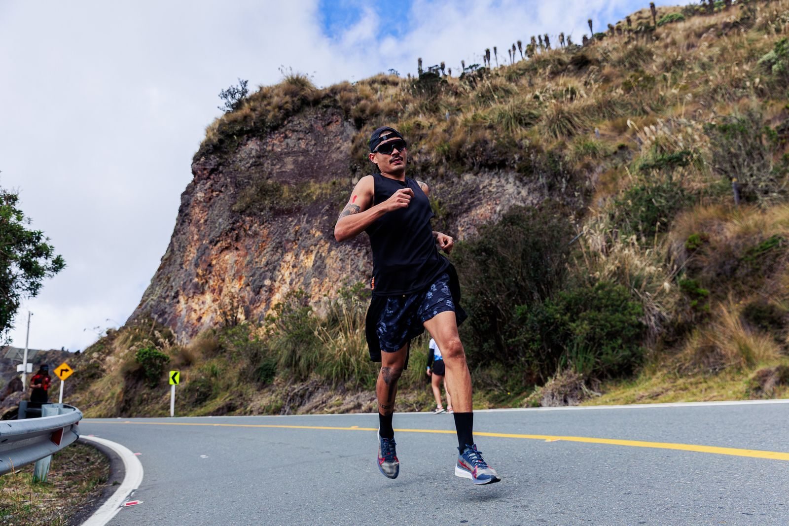 Hombre subiendo una carretera de montaña con pasos cortos durante su entrenamiento en cuestas