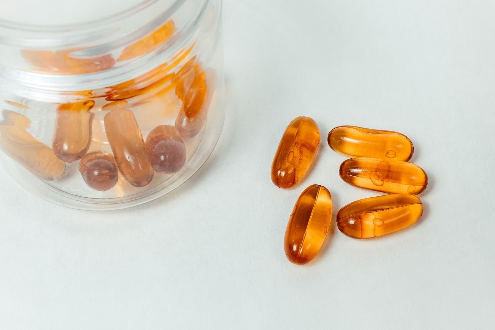 Supplement capsules spilling out of a glass jar
