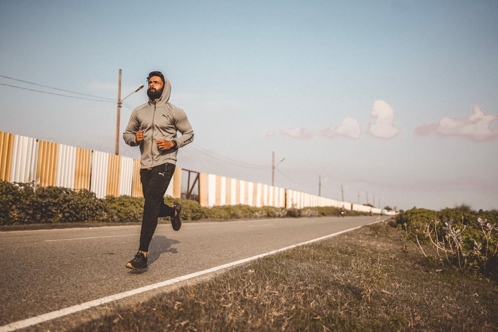 Corredor haciendo una tirada larga para su primer maratón por una carretera vacía