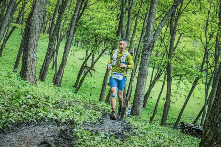 Corredor de trail con dorsal en un bosque frondoso, imagen ilustrativa de la Trail del Senglar 2027