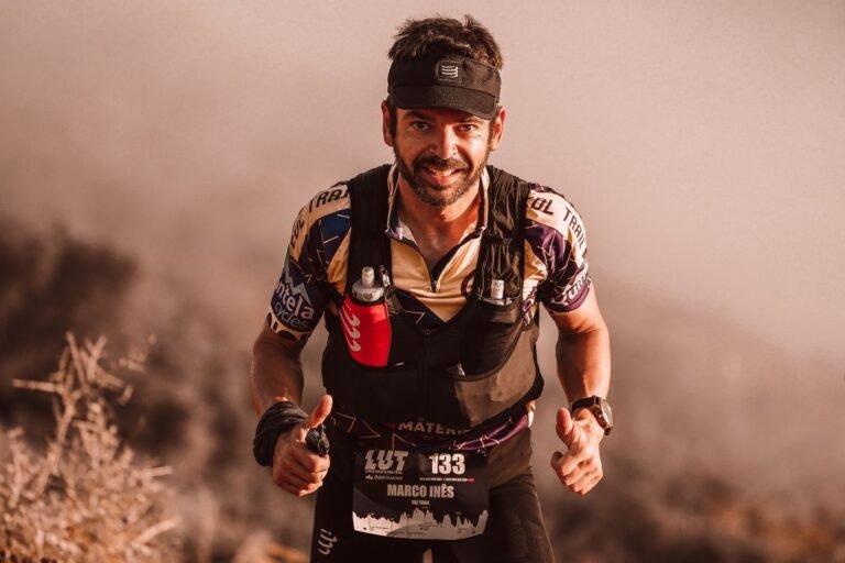 Trail runner with a hydration vest and soft flasks during a mountain race