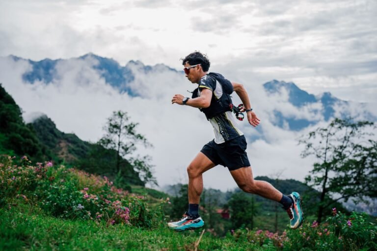 Trail runner running down a mountain path among the clouds