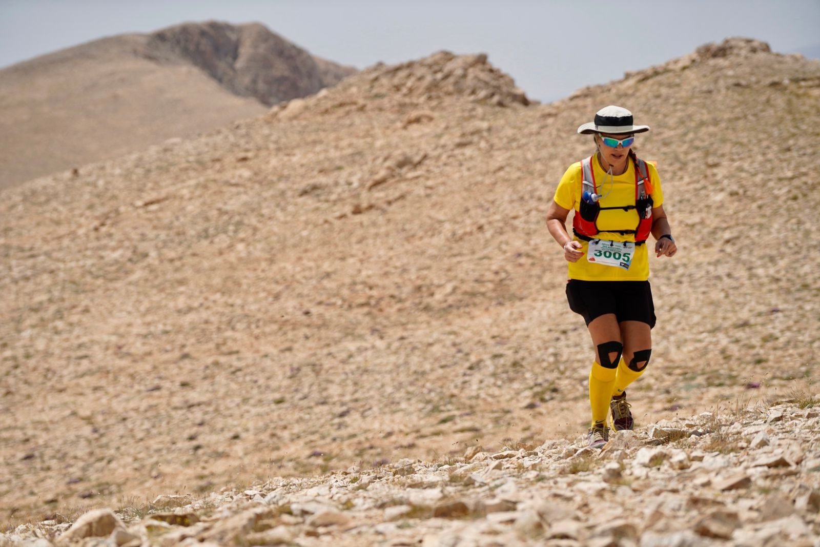 Trail runner moving across rocky mountain terrain