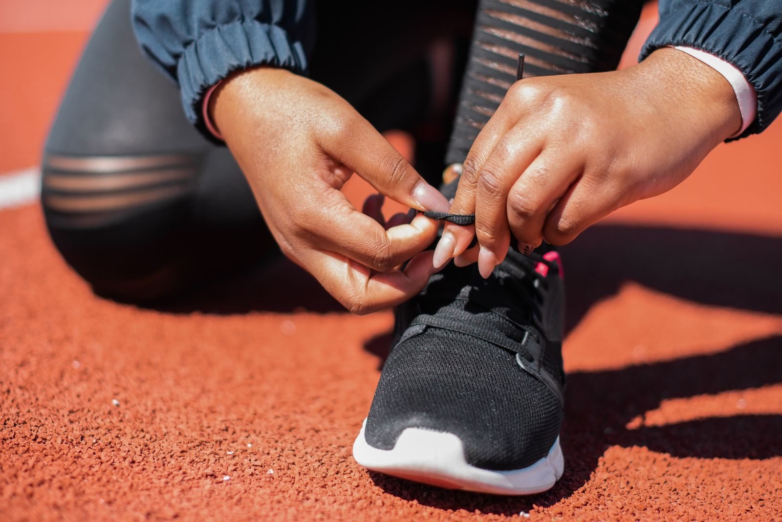 Athlete tying training shoes on an athletics track