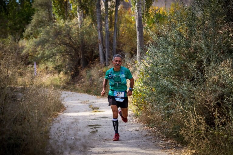 Trail runner on a path through vegetation, illustrative photo for Vallalta Trail 2026