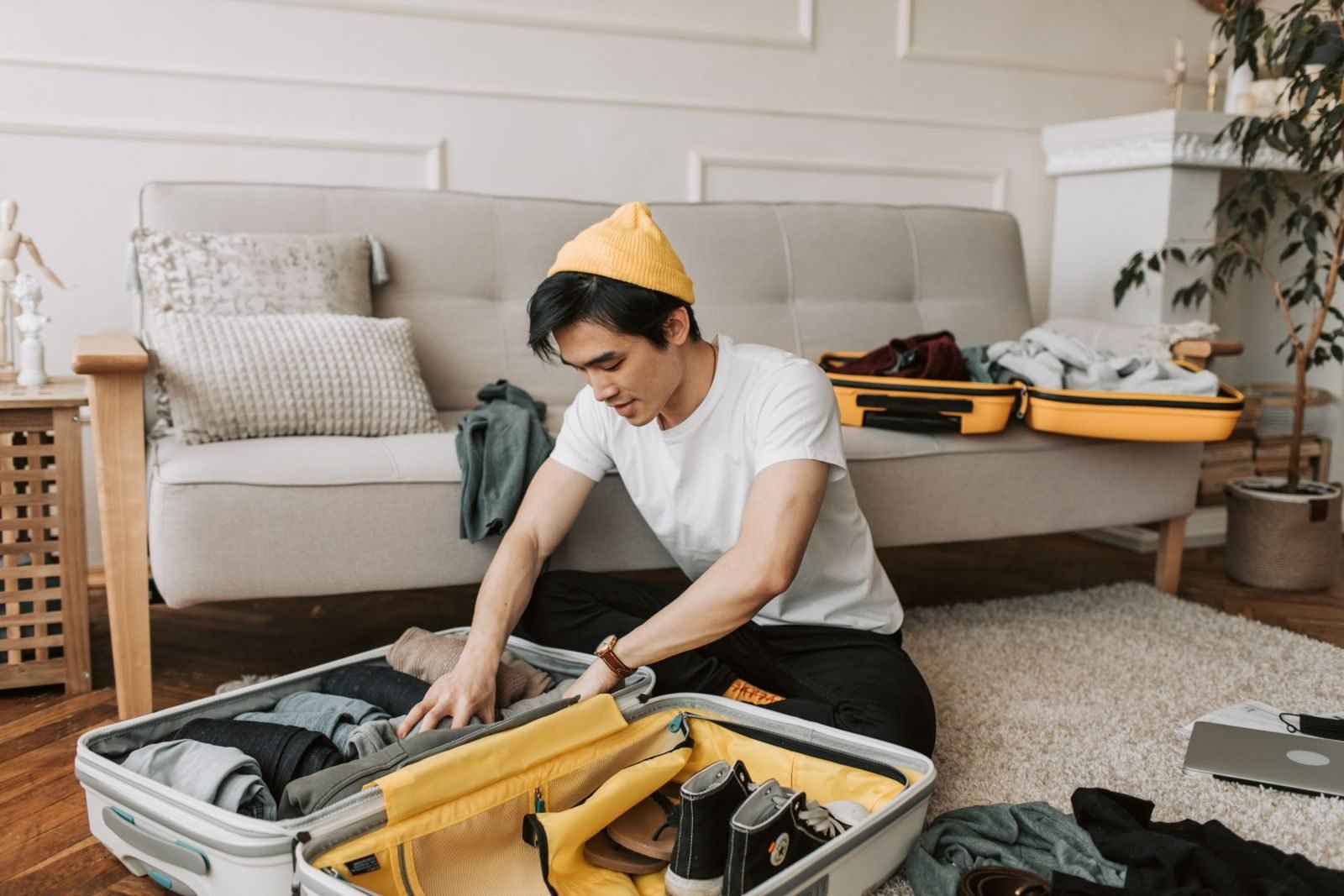 Joven preparando la maleta en casa antes de viajar a una carrera