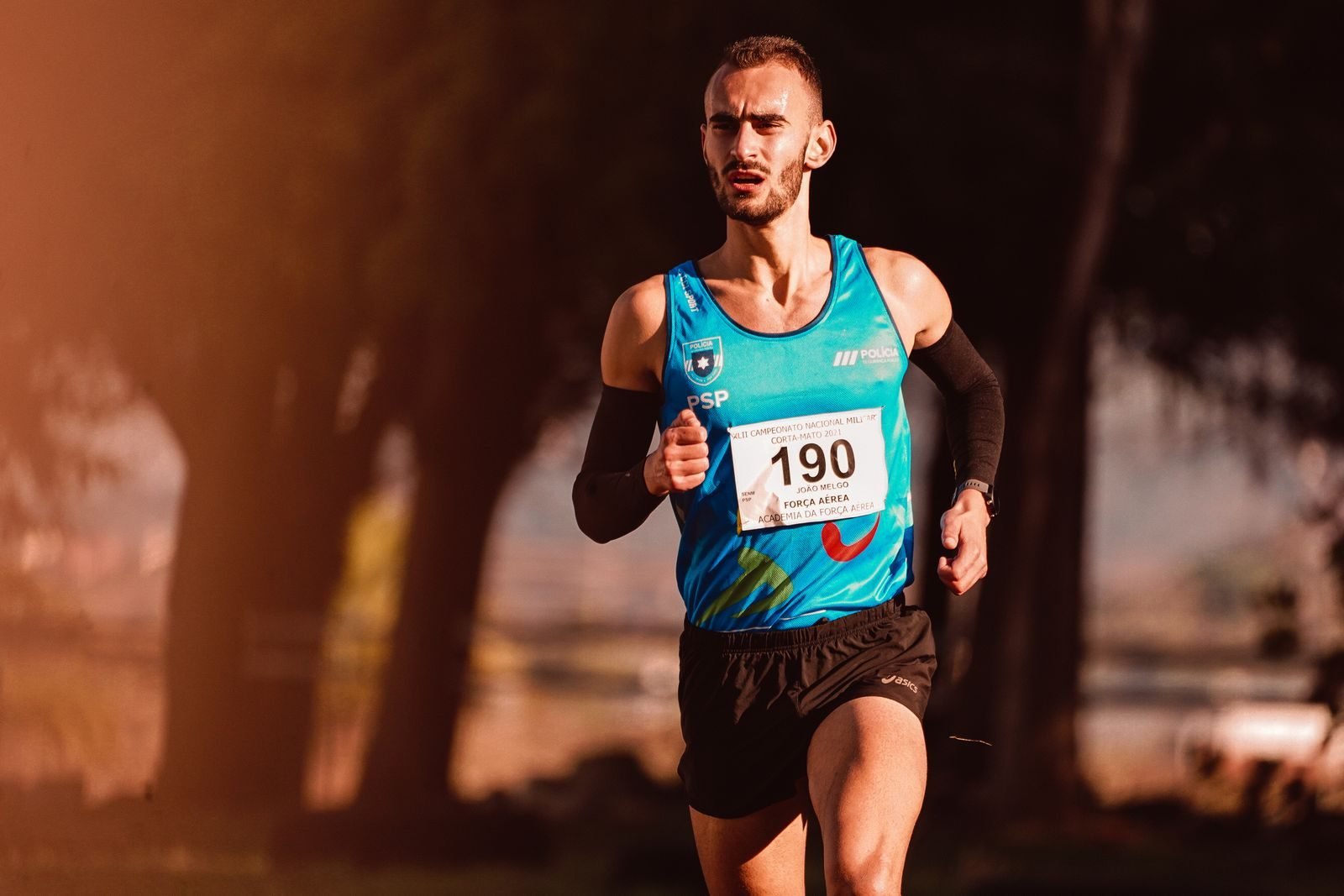 Runner with a bib in a park race after weeks of building weekly running distance
