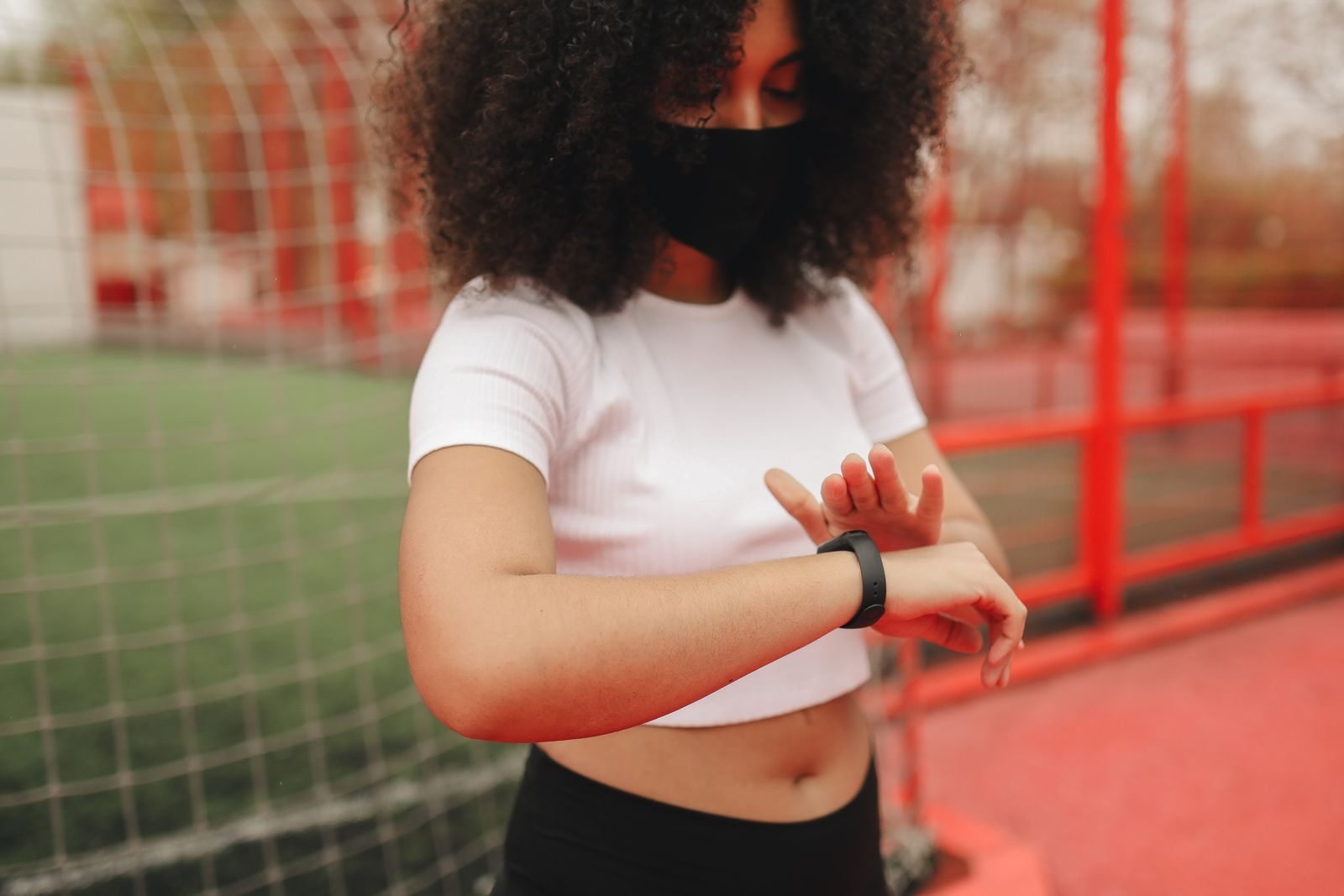 Woman checking her smartwatch outdoors, gifts for female runners