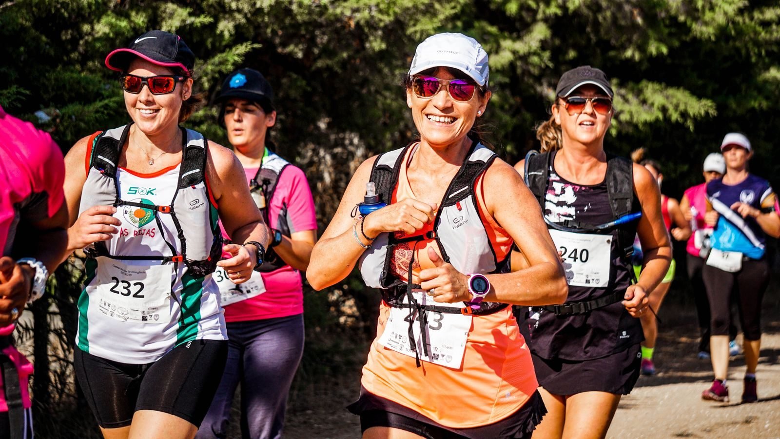 Group of smiling women with bibs in a race