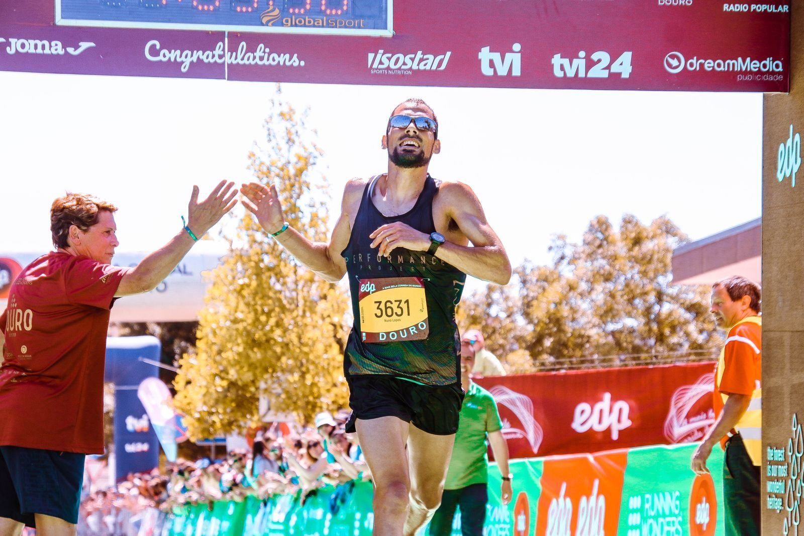 Runner celebrating with arms raised at a marathon finish line, like the Moment of the Year nominees