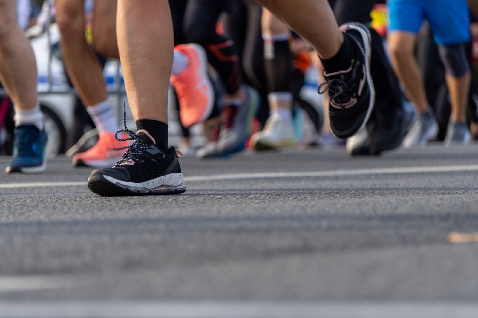 Pies de corredores en un maratón, donde se usan zapatillas con placa de carbono