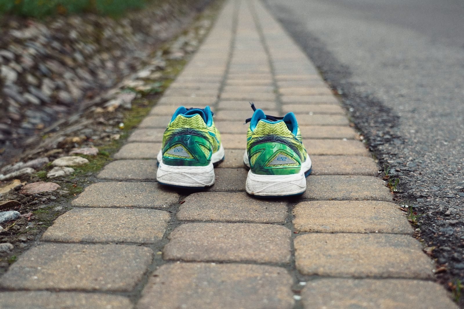 Zapatillas de running de colores sobre un camino adoquinado