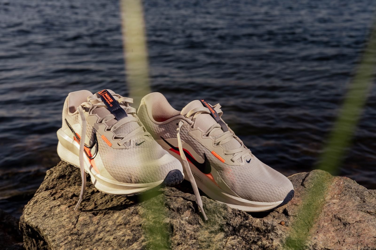 Zapatillas de running grises sobre unas rocas junto al agua