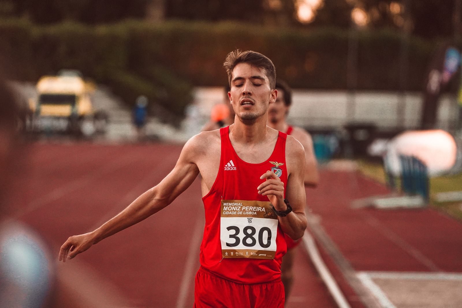 Corredor joven cruzando la línea de meta en una pista